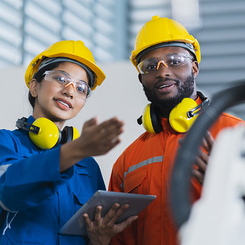 Deux intérimaires qui travaille avec des casques dans le domaine de l'industrie.